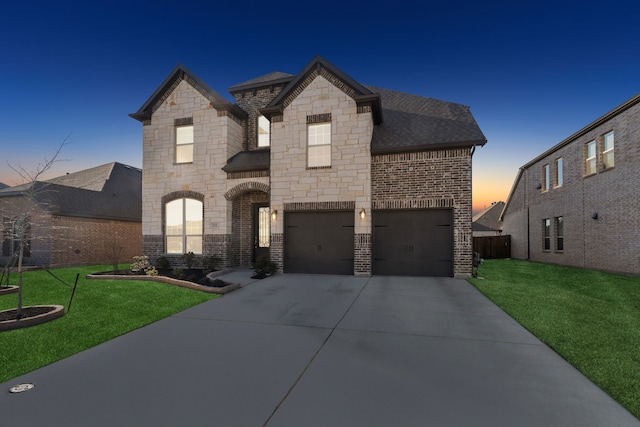 french country inspired facade featuring a lawn and a garage