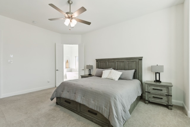 bedroom with ceiling fan, ensuite bath, and light carpet