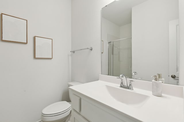 bathroom with vanity, a shower with shower door, and toilet