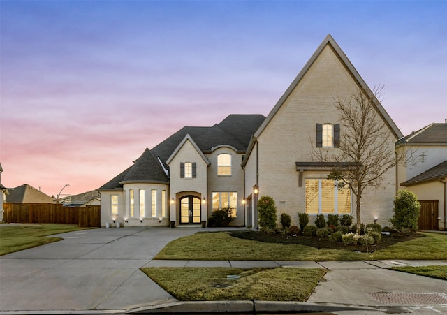 french country home featuring a yard and french doors