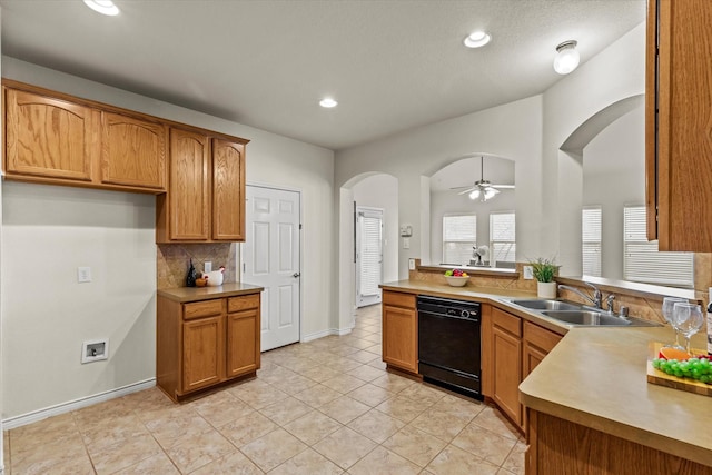 kitchen featuring decorative backsplash, ceiling fan, sink, light tile patterned floors, and black dishwasher