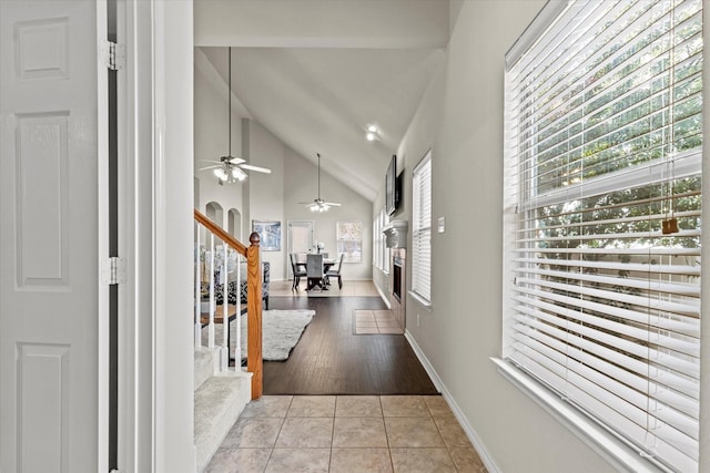 tiled entrance foyer featuring vaulted ceiling, a wealth of natural light, and ceiling fan