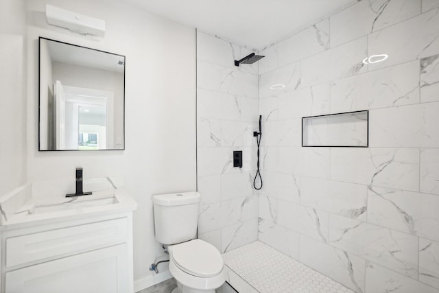 bathroom with a tile shower, vanity, toilet, and a wall mounted AC