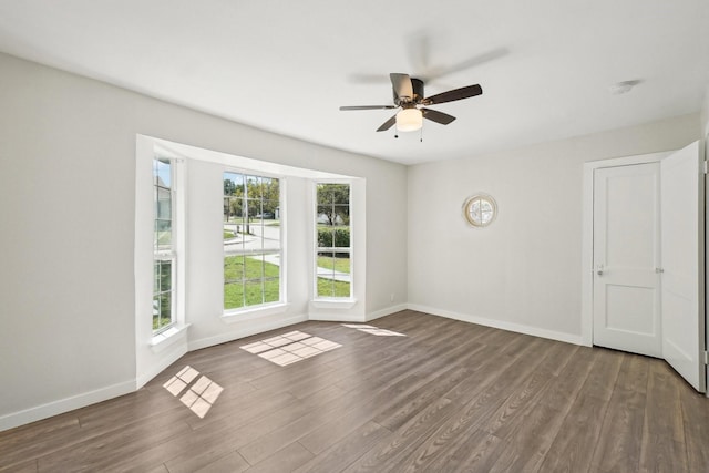 unfurnished room featuring dark hardwood / wood-style flooring and ceiling fan