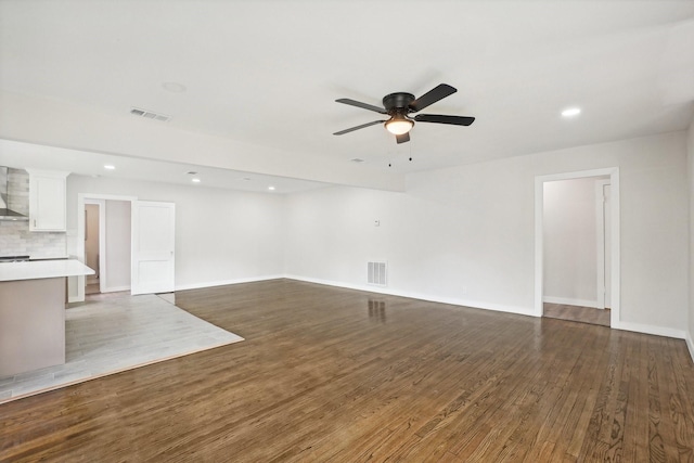 unfurnished living room featuring dark hardwood / wood-style flooring and ceiling fan