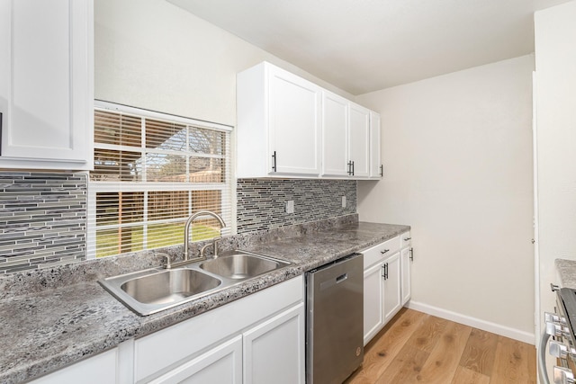 kitchen featuring appliances with stainless steel finishes, white cabinetry, light hardwood / wood-style floors, sink, and stone countertops