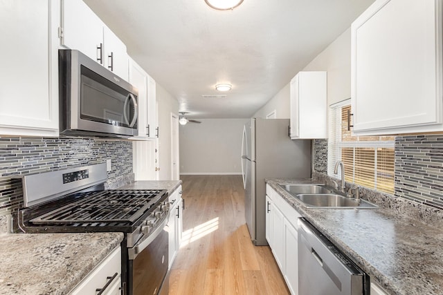 kitchen with stainless steel appliances, light hardwood / wood-style floors, white cabinets, and sink