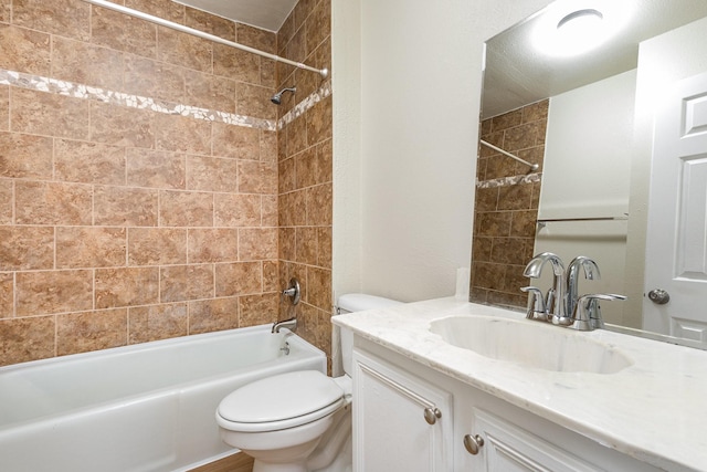 full bathroom featuring toilet, tiled shower / bath combo, and vanity