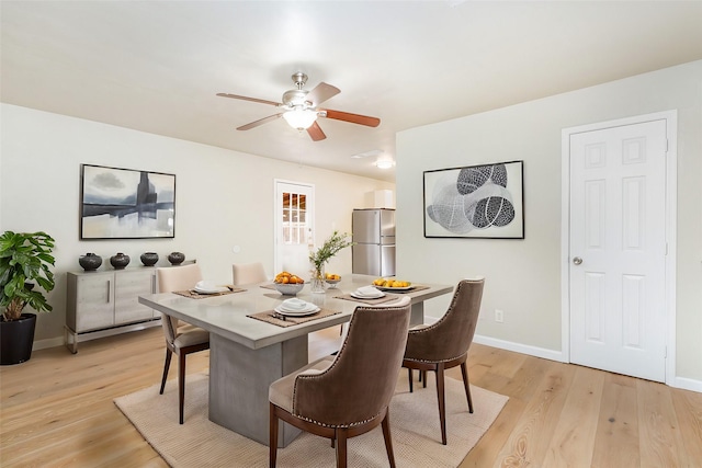 dining room with ceiling fan and light hardwood / wood-style floors