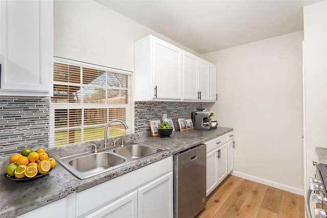 kitchen with white cabinets, appliances with stainless steel finishes, decorative backsplash, sink, and light hardwood / wood-style flooring