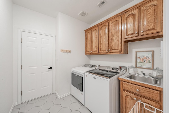 washroom with separate washer and dryer, sink, light tile patterned flooring, and cabinets