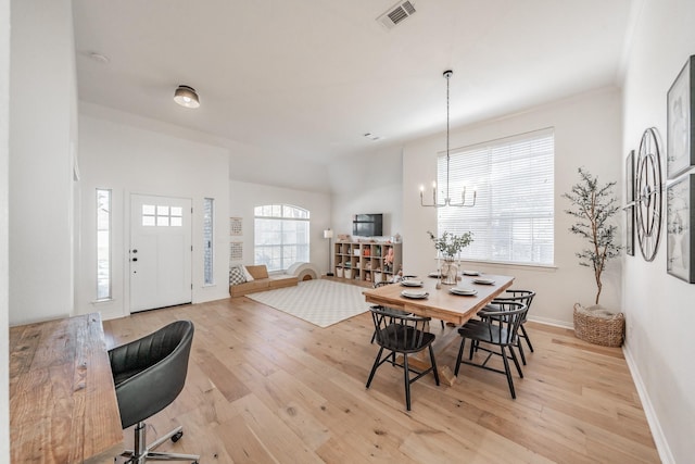 dining space with plenty of natural light, a notable chandelier, and light wood-type flooring