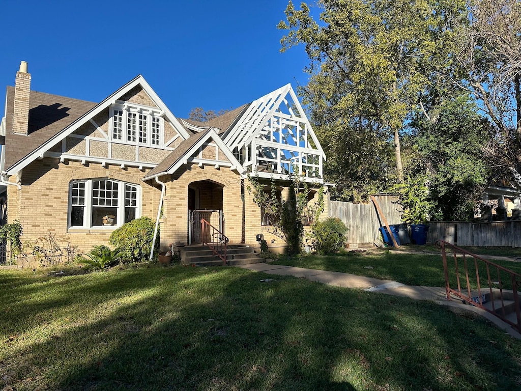 tudor home with a front lawn