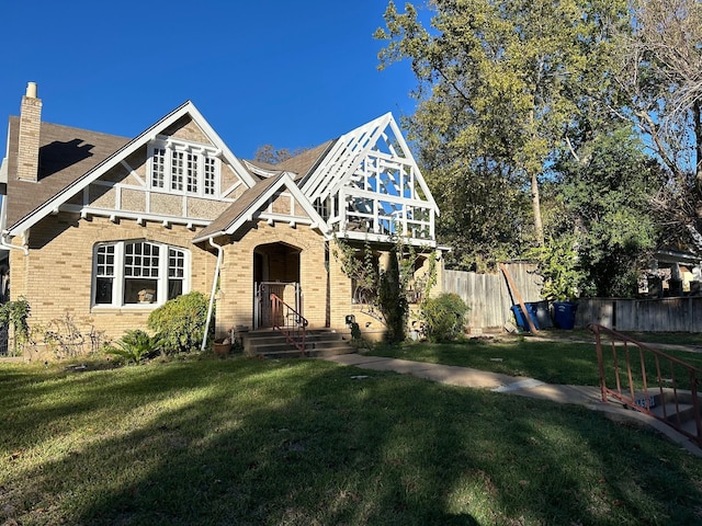 tudor home with a front lawn