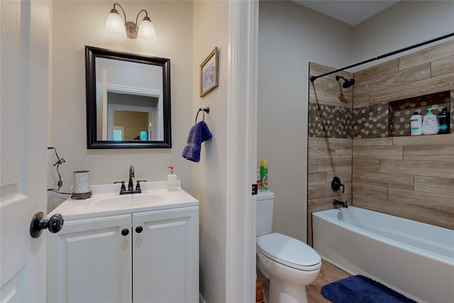 full bathroom featuring tiled shower / bath combo, vanity, and toilet