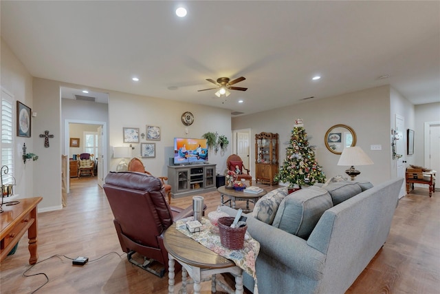 living room with light hardwood / wood-style flooring and ceiling fan