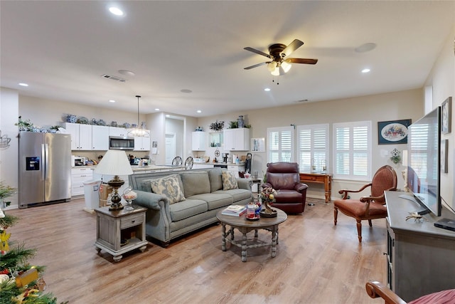 living room featuring ceiling fan and light hardwood / wood-style flooring