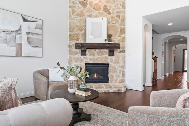 living room featuring dark hardwood / wood-style flooring, a fireplace, and ornamental molding