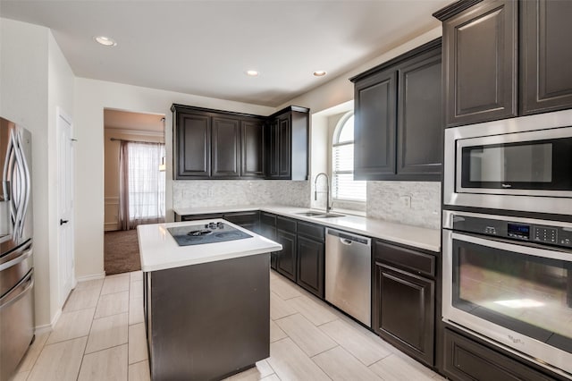 kitchen featuring decorative backsplash, appliances with stainless steel finishes, a kitchen island, and sink