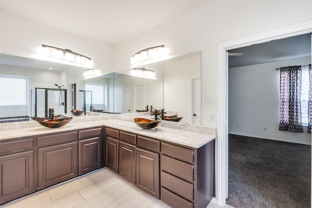 bathroom featuring vanity and a shower with door