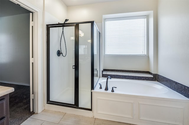 bathroom with tile patterned flooring, vanity, and separate shower and tub