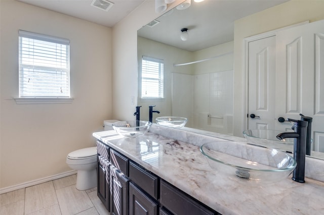 bathroom with tile patterned floors, vanity, toilet, and a shower