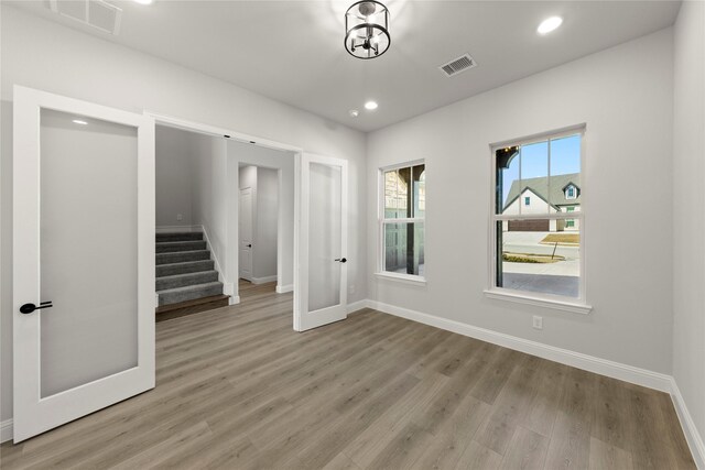 spare room with a chandelier and light hardwood / wood-style flooring