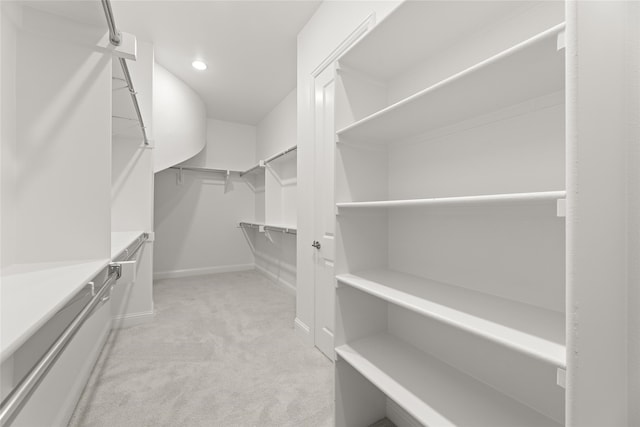 walk in closet featuring light carpet