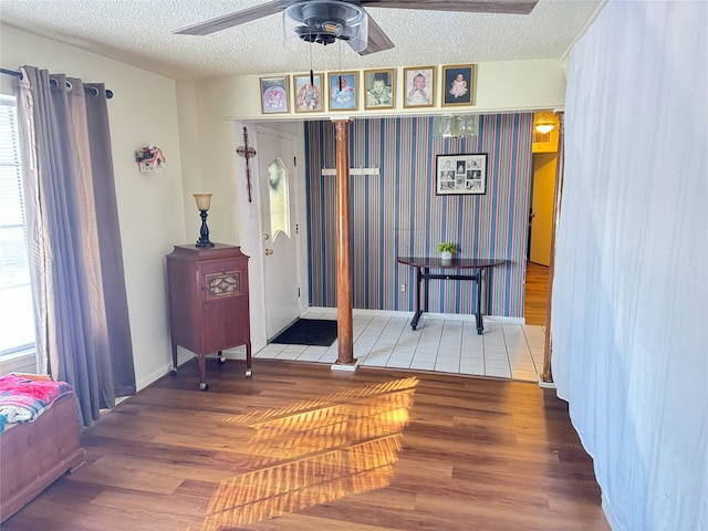 foyer entrance featuring hardwood / wood-style floors, plenty of natural light, ceiling fan, and a textured ceiling