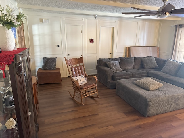 living room with a healthy amount of sunlight, a textured ceiling, ceiling fan, and dark wood-type flooring