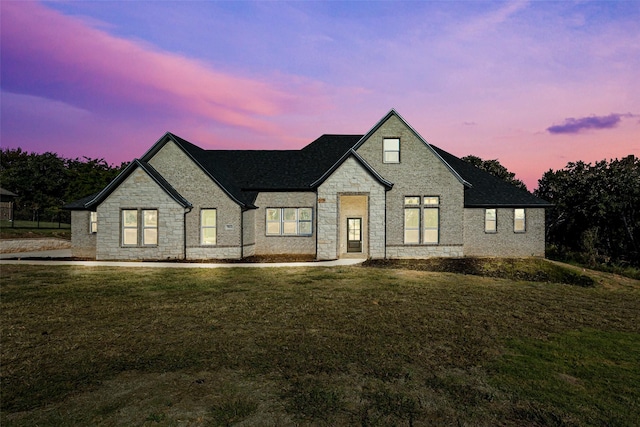 french country home featuring a lawn