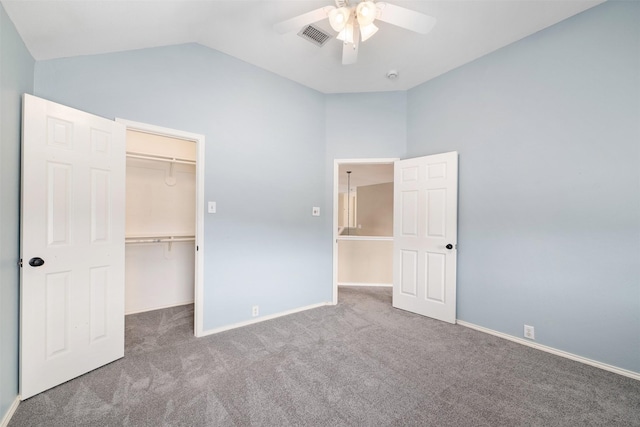 unfurnished bedroom featuring a closet, lofted ceiling, a spacious closet, and carpet