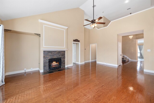 unfurnished living room with ceiling fan, wood-type flooring, a fireplace, and high vaulted ceiling