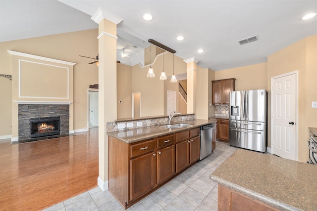 kitchen featuring pendant lighting, decorative columns, sink, ceiling fan, and stainless steel appliances