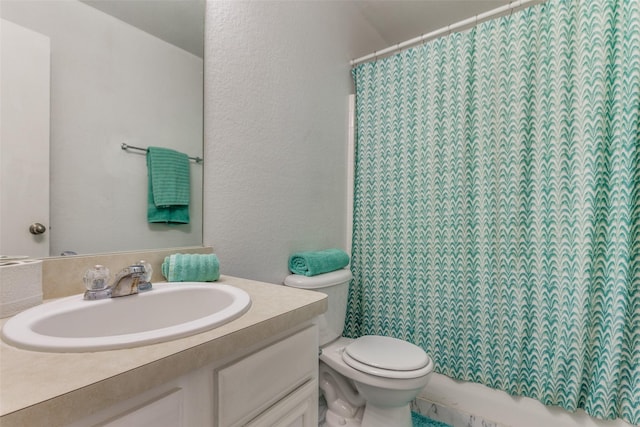 bathroom featuring curtained shower, vanity, and toilet