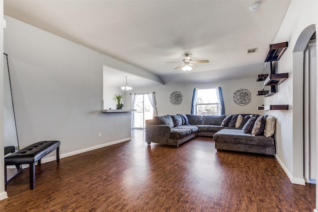 living room with ceiling fan with notable chandelier and dark wood-type flooring