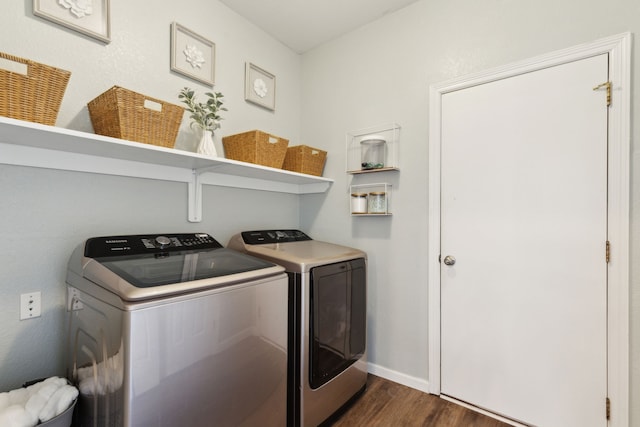 clothes washing area featuring washer and clothes dryer and dark wood-type flooring