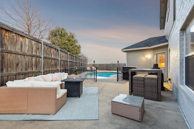 patio terrace at dusk featuring a fenced in pool and an outdoor hangout area