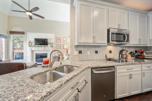 kitchen with white cabinets, sink, a fireplace, and appliances with stainless steel finishes