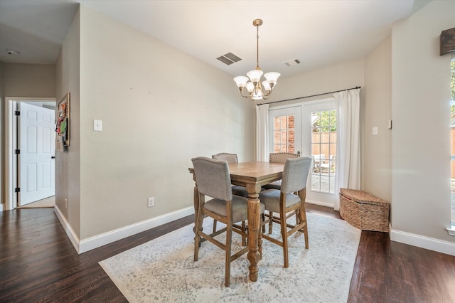 dining area featuring dark hardwood / wood-style floors and an inviting chandelier