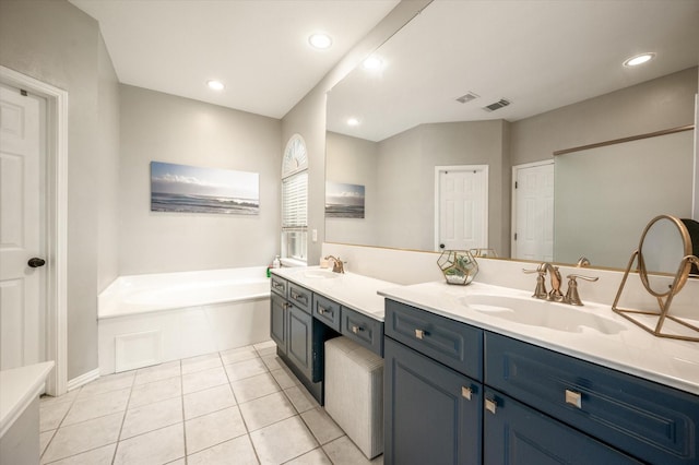 bathroom featuring a tub to relax in, tile patterned floors, and vanity