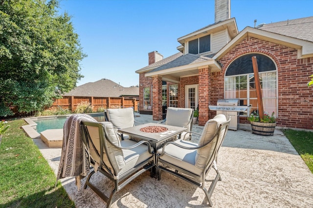 view of patio with area for grilling and a fenced in pool