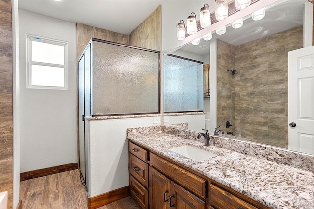 bathroom featuring hardwood / wood-style flooring, vanity, and walk in shower