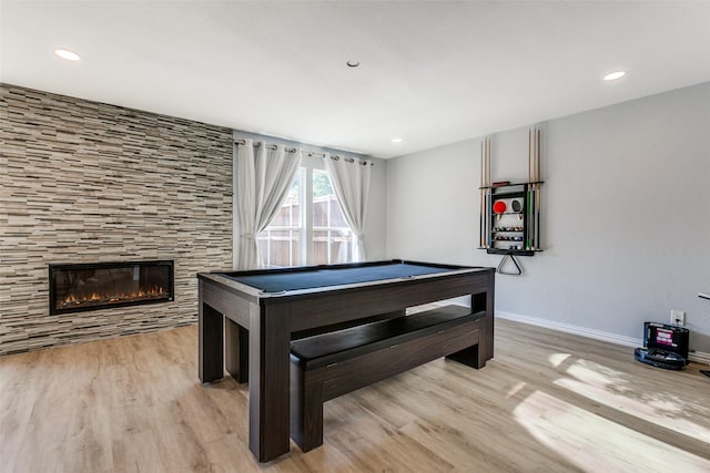 recreation room featuring pool table, light hardwood / wood-style floors, and a tile fireplace