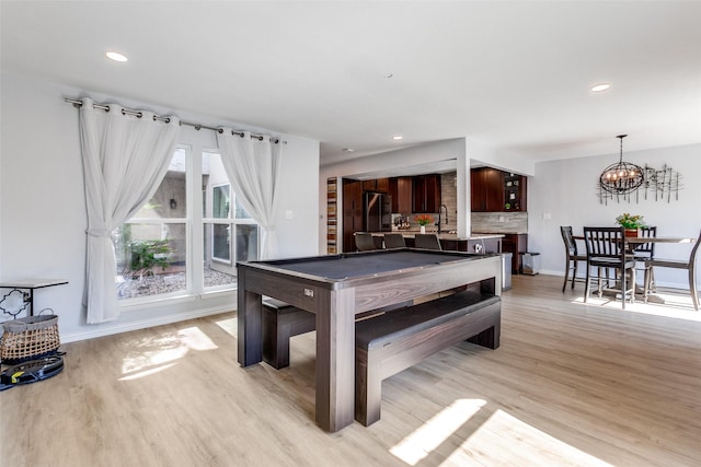 recreation room with an inviting chandelier, billiards, and light hardwood / wood-style flooring