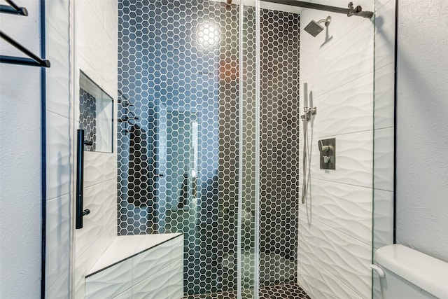 bathroom featuring walk in shower and toilet