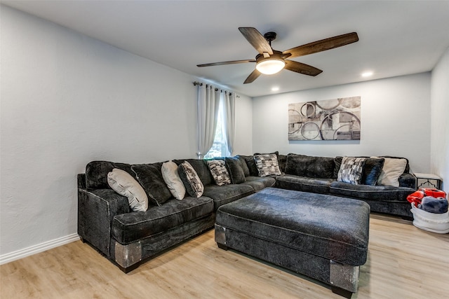 living room with ceiling fan and light wood-type flooring