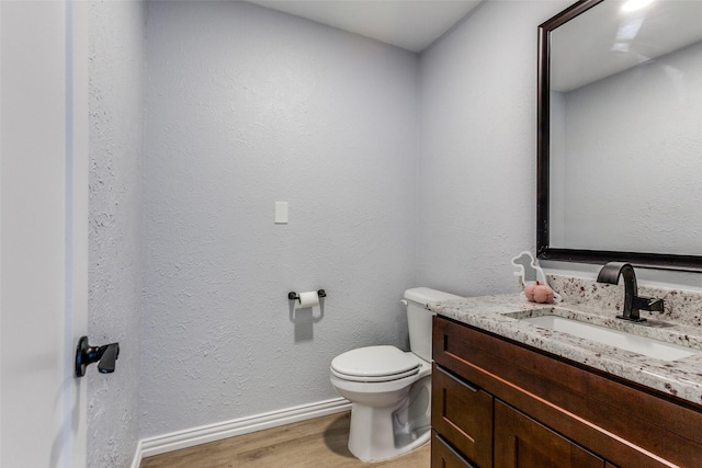 bathroom featuring hardwood / wood-style floors, vanity, and toilet