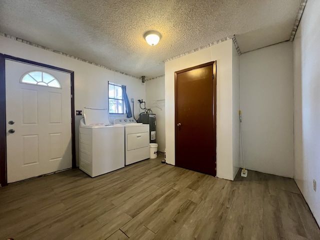 laundry room featuring a textured ceiling, separate washer and dryer, light hardwood / wood-style floors, and water heater