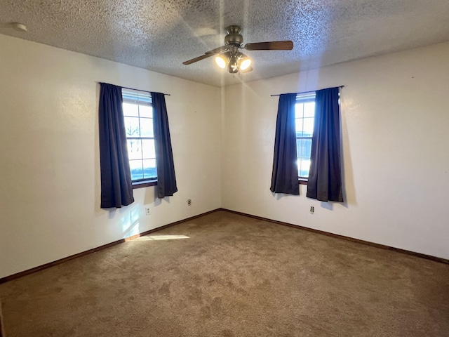 spare room with carpet flooring, ceiling fan, and a textured ceiling